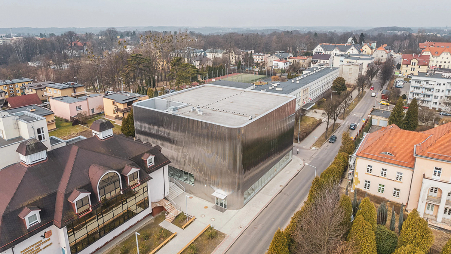 SLAS Architekci окутывает польский концертный зал зеркальным стальным фасадом